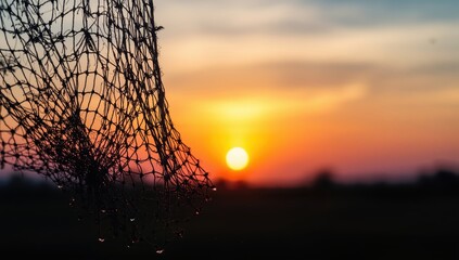 Fototapeta premium Silhouette of fishing net against a sunrise