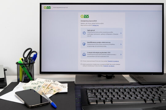 Czestochowa, Poland - February 19, 2026: Monitor with displayed ZUS website, social security contribution, computer keyboard, desk, banknotes,