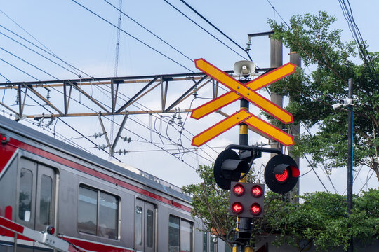 Railway Crossing Alert Red Lights and Approaching Train in Urban Setting.