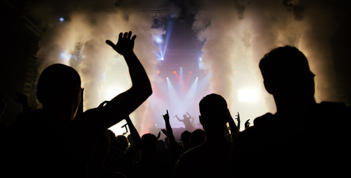 Cheering crowd with hands raised at concert. Summer and festival vibes. 