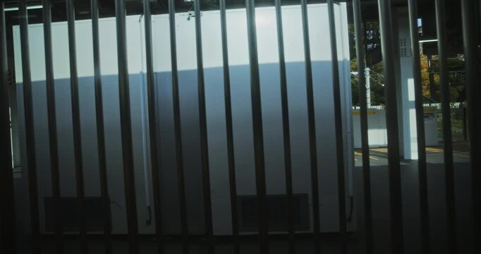 View through train window of gate at Japanese station