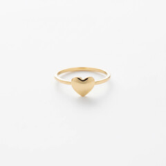  Small heart gold ring on white background.