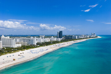 Obraz premium Drone aerial view of Miamis sandy beach. Miami coastline. Wide drone shot of Miami Beach and ocean waves. Miami Beach from above. Oceanfront Miami resorts by drone.