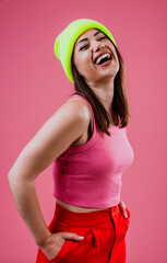 Happy young woman laughing wearing neon beanie