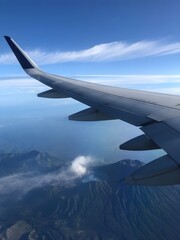 Obraz premium Amazing mountain view from airplane window. A mountainous landscape seen through airplane window with the airplane wing visible