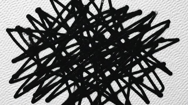 Black ink scribbles expanding on textured white paper creating abstract artistic shapes and forms