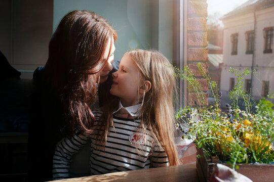 Smiling girl with her mother in a cafe