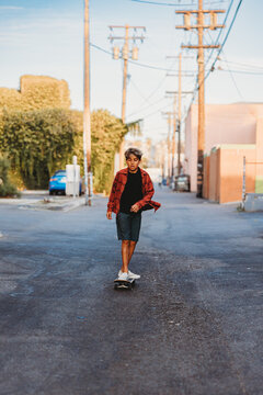 Boy riding his skateboard on an alley way.