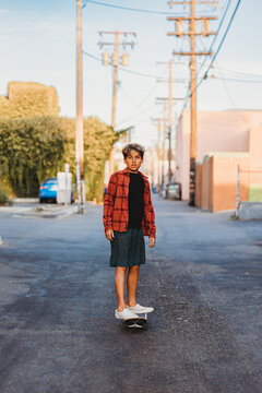 Boy riding his skateboard on an alley way.