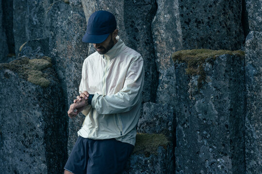 Trail runner checks his watch to see his pace