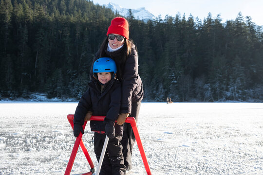 Woman and Young Boy Skating on Frozen lake in canada
