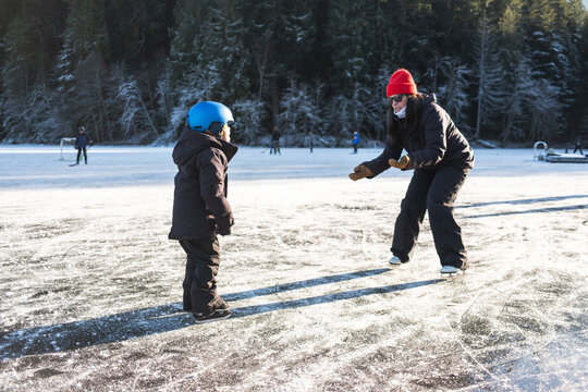 Woman and Young Boy Skating on Frozen Pond