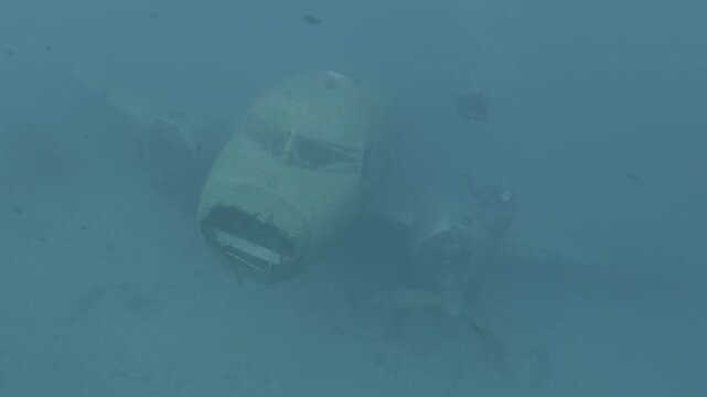 log footage of scubadivers exploring airplane wreck underwater