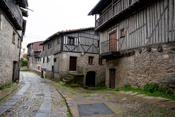 Naklejka premium Narrow cobblestone street with traditional buildings.. La Alberca, in the province of Salamanca, Spain