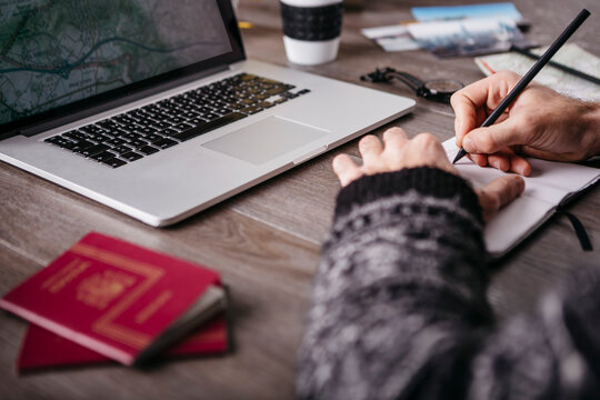 Man writing in notebook planning a trip