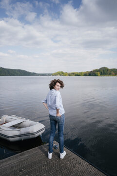 Woman standing on jetty with moored boat