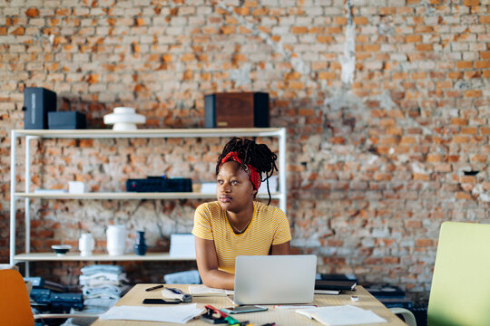 Young woman sitting at table using laptop
