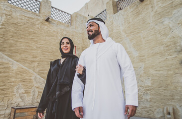 Happy couple spending time in Dubai. man and woman wearing traditional clothes making shopping in...