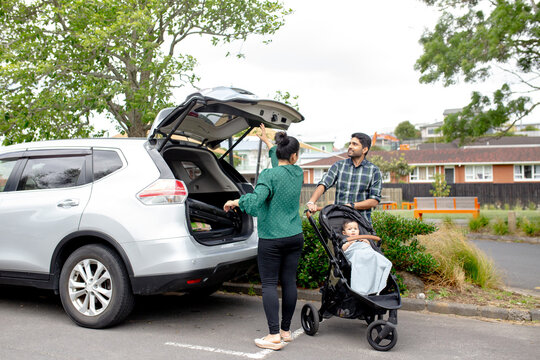 Indian couple unloading car boot on the roadside at the park