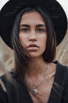 Portrait of fashionable young woman wearing black hat