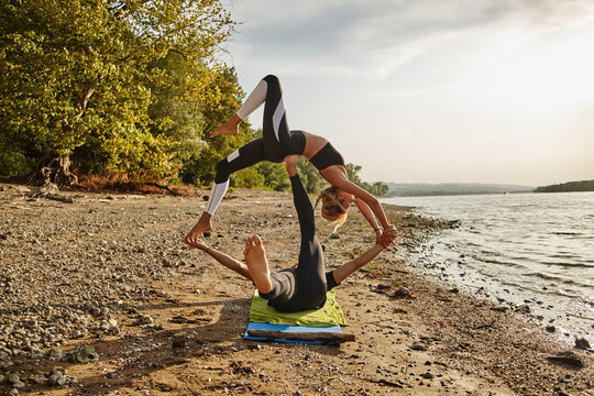 Young man and woman practicing Acro Yoga
