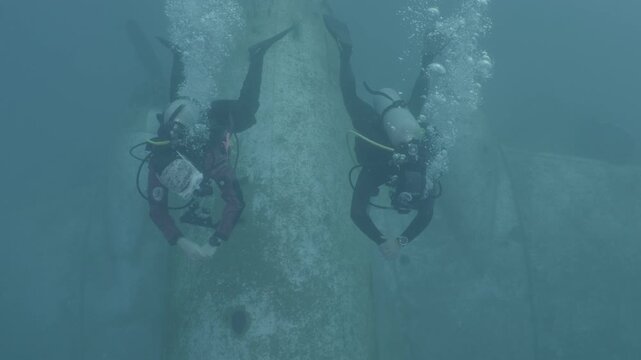 log footage of scuba divers are exploring a c47 dakota airplane wreck underwater 