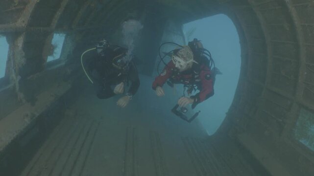 log footage of scuba divers are exploring a c47 dakota airplane wreck underwater 