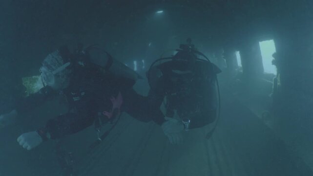 log footage of scuba divers are exploring a c47 dakota airplane wreck underwater 