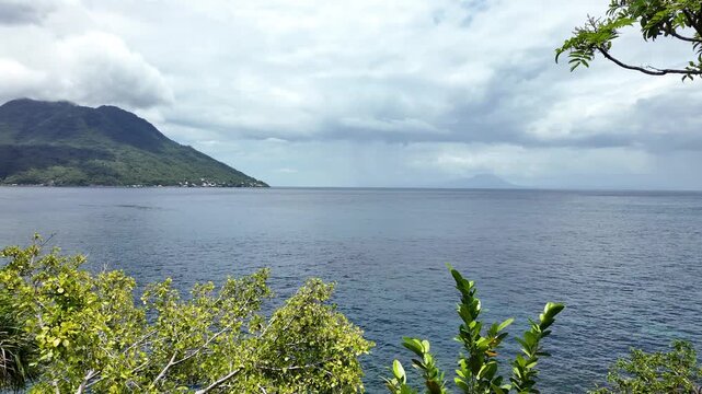 This 4K raw footage captures the bustling maritime activity at Ternate Harbor in North Maluku, Indonesia. The video features various vessels, including passenger ferries and traditional wooden boats