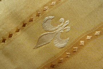 Backdrop - beige fabric with embroidered fleur de lis symbol © Anna