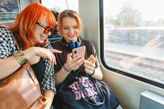 Smiling mother and daughter sharing a joyful subway moment together