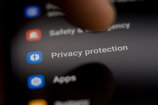Close up of a smartphone screen showing the privacy protection settings menu with a finger ready to tap the icon, representing mobile data security, user privacy controls, and digital safety.