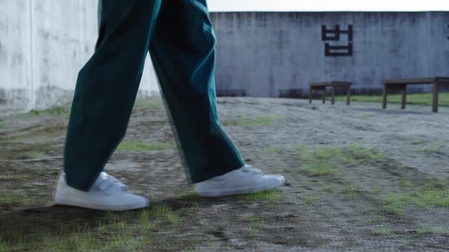 Prisoner in prison yard bouncing tennis ball