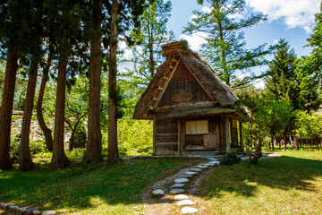 Historic Japanese village Shirakawa-go in summer with traditional gassho-zukuri houses, steep thatched roofs and green mountain landscape