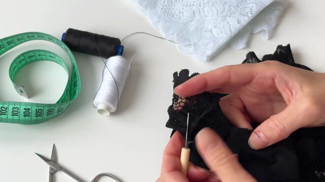 A woman carefully unpicks a seam on lace fabric with ripper.