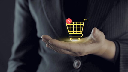 Businessman holding glowing shopping cart icon with notification symbol, online shopping and ecommerce concept, digital payment, retail technology, mobile purchase and customer experience.