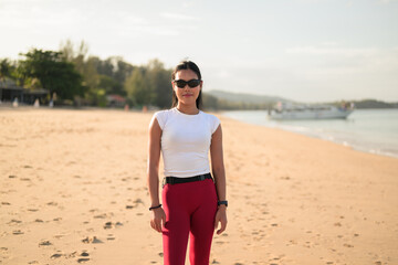 Fit Asian Woman in Sportswear Standing on Beach During Summer Workout