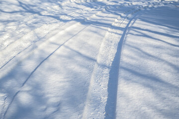 Snow-covered road with tire tracks, difficult driving conditions before the snow removal service...