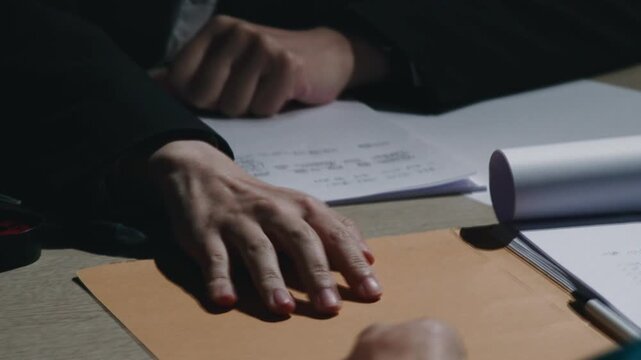 Two people holding hands while discussing documents at table