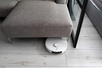 White robot vacuum cleaner in living room
