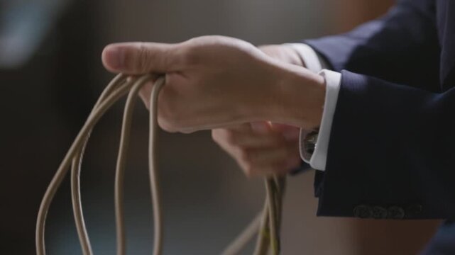 Man's hand holding rope