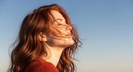 Fototapeta premium Woman gazing upward with a sense of freedom against a clear sky backdrop.