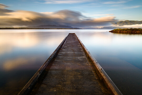 view along a jetty into a lake using a slow shutter speed
