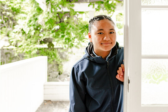 Teenage Samoan girl leaning against the door frame