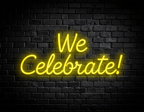 Leuchtende gelbe Neonschrift "We Celebrate!" auf dunkler Backsteinmauer