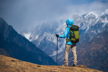 Backpacking woman hiking on high altitude mountain top
