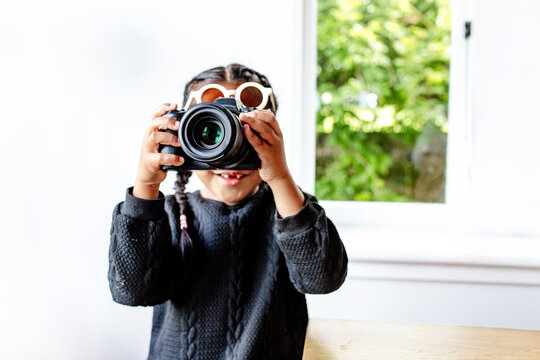 Young Samoan boy holding a large camera up