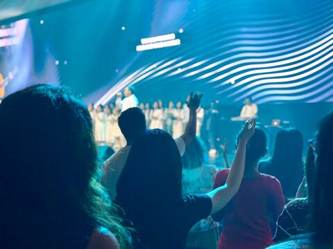 Contemporary church worship scene in blur, believers raising hands in prayer and praise. BSD, Indonesia - February 22, 2026