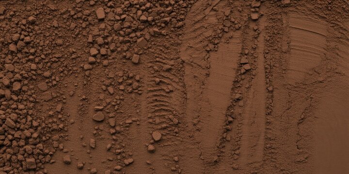 Close-up of fine brown cocoa powder with rich clumpy texture and central depression. Earthy organic material in warm tones, ideal for food, baking, and natural product photography. 