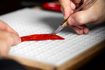 cutting and breaking red glass with a glass cutter